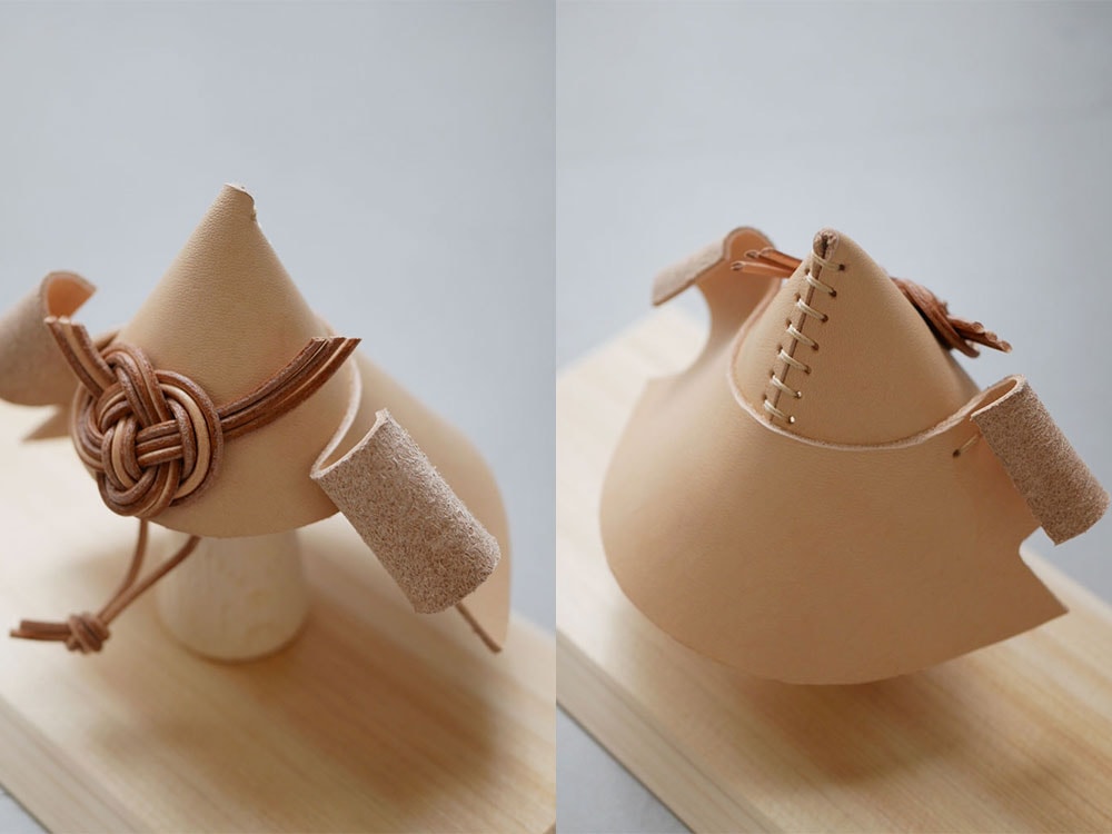 Comore Sunブランドのこども用ヌメ革兜が木製スタンドにセットされている