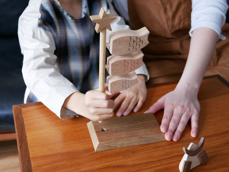 P.F WORK SHOP製の木製鯉のぼりと兜セット。ブナ材とチーク材を使用し、横15cm×高さ25cmのサイズ。子供の日の飾りに最適な日本製デザイン