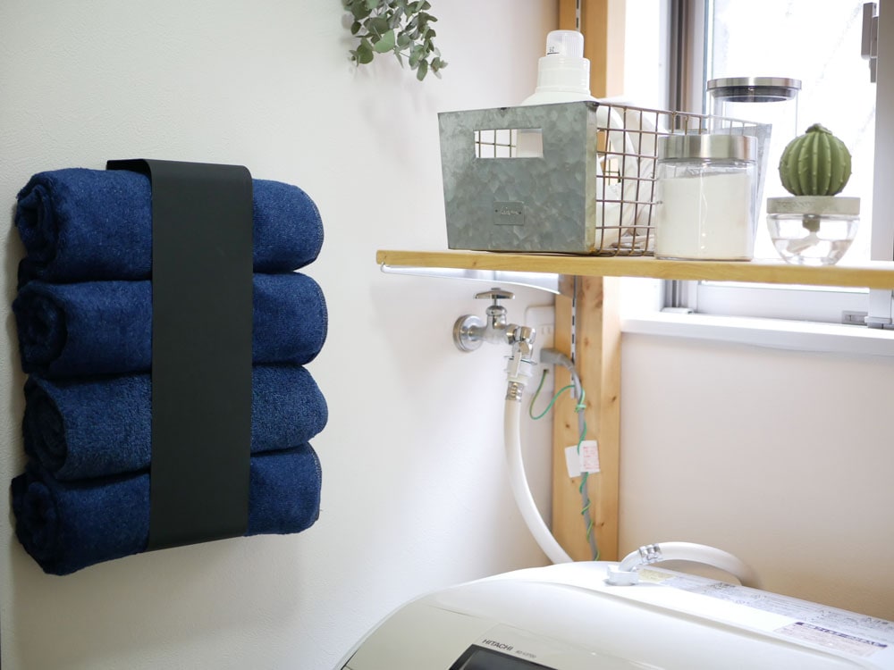 YAMAZAKI製タワー型マグネットバスタオルホルダーがスチール製の棚に設置され、約4枚のバスタオルを掛けている様子