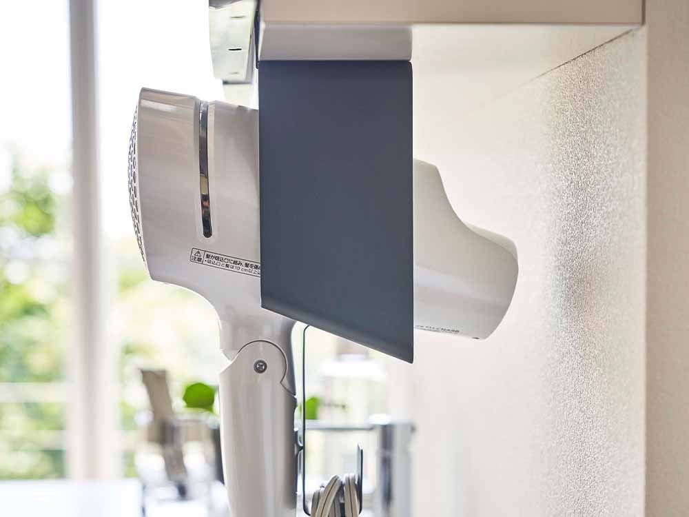 棚下に取り付けられたタワーのドライヤーホルダー