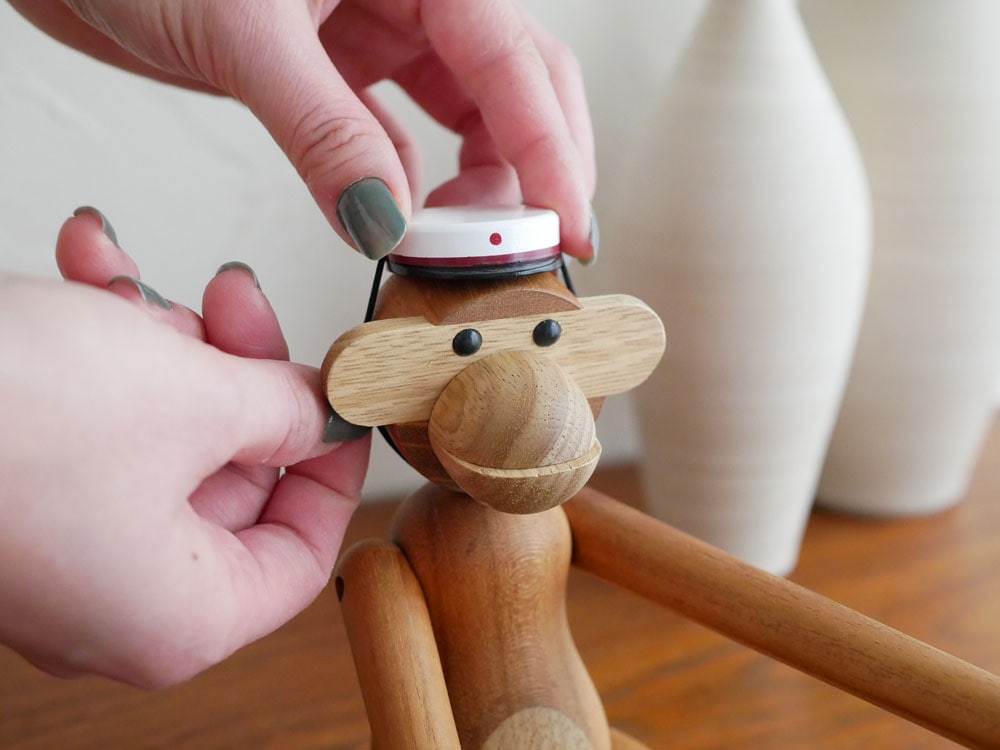 カイ ボイスン製の木製サルフィギュアがスチューデントキャップをかぶっている画像