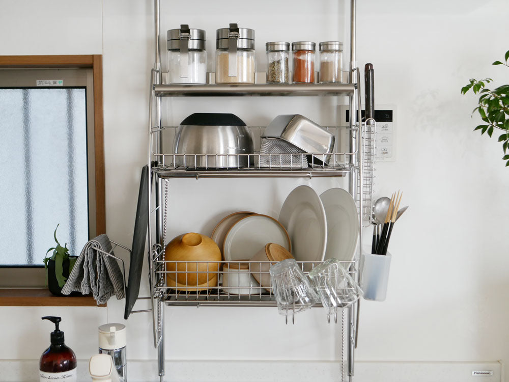 棚付きのステンレス製流れるつっぱり水切りラックがキッチンカウンターに設置されている様子