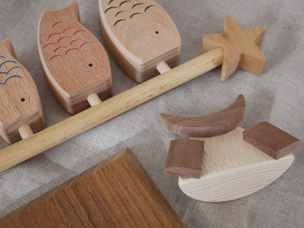 P.F WORK SHOP製の木製鯉のぼりと兜セット。ブナ材の鯉のぼりと兜、マホガニー材の星、チーク材の鯉のぼり台が組み合わさった伝統的なデザイン