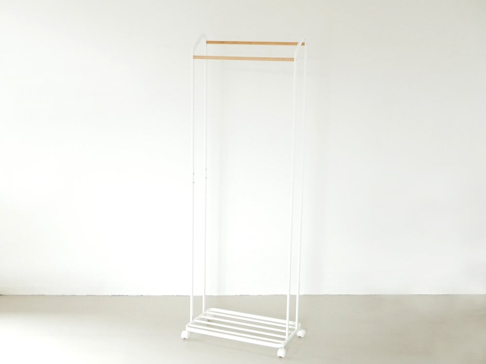 YAMAZAKI/towerのキャスター付きハンガーラックに衣類が掛けられている家庭用収納用品の画像