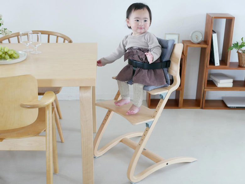 Leanderクッションが置かれた木製の椅子と床