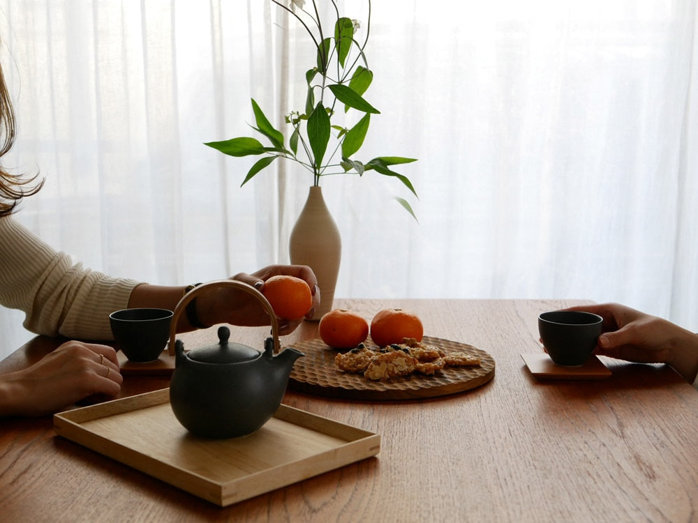 白磁の急須とカップ、果物を添えて