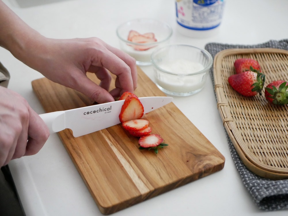 京セラココチカルセラミックナイフセットと果物、食器類が木製カッティングボード上に配置された画像