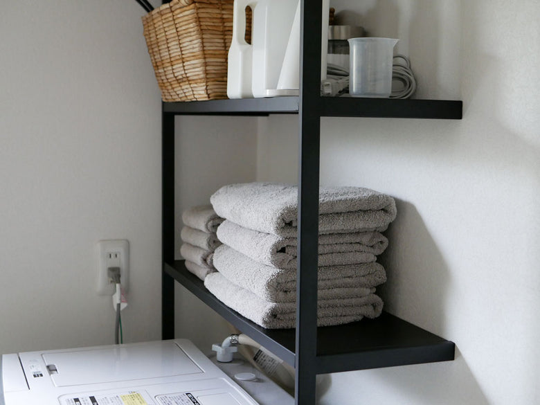 タワー製の立て掛けランドリーシェルフがスチール本体と天然木ハンガーバーで組み立てられている様子