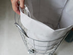 BRIDのランドリーストレージ ラウンド 33L。グレーとシルバーのプラスチック製バスケットにハンドルが付いた収納ボックス。
