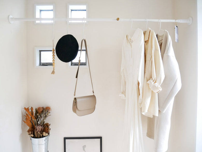 鉄製テンションロッドに掛けられた洋服ハンガーとロープ