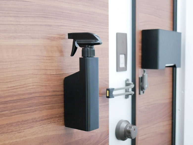 タワーのマグネットスプレーボトルがドアに取り付けられている