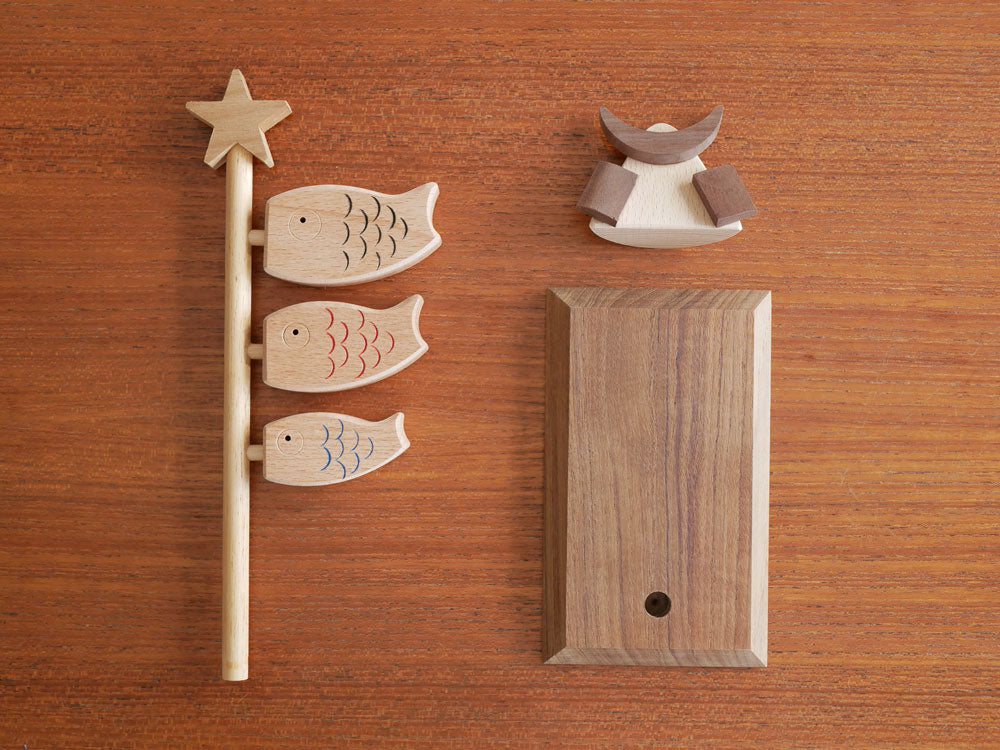 P.F WORK SHOP製の木製鯉のぼりと兜のセット。カラフルな鯉が浮かび、伝統的なデザインで高さ25cmの装飾品。