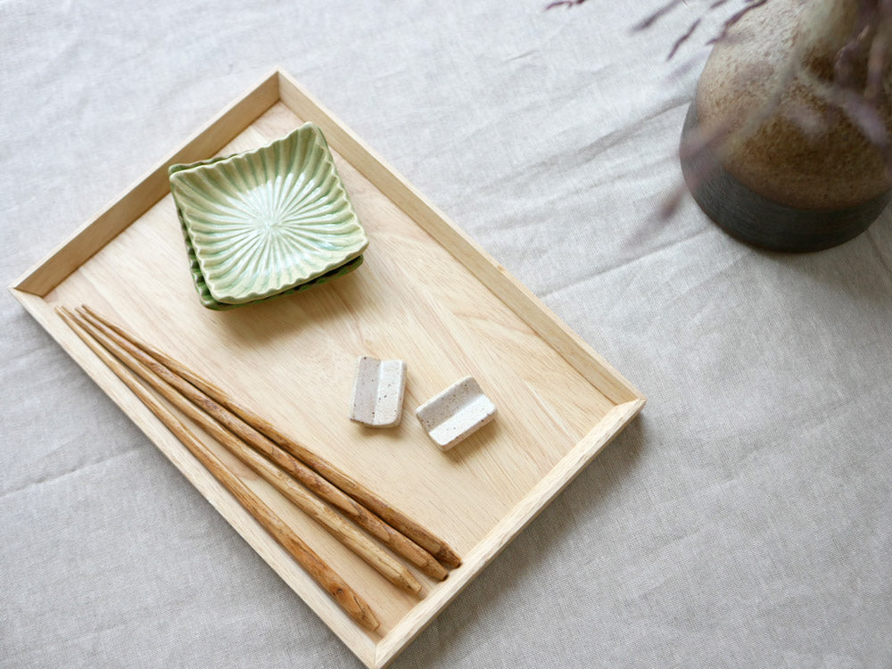 「sarasa design×イブキクラフト」の白色陶器箸置き。シンプルで上品なデザインがテーブル上に配置されています。