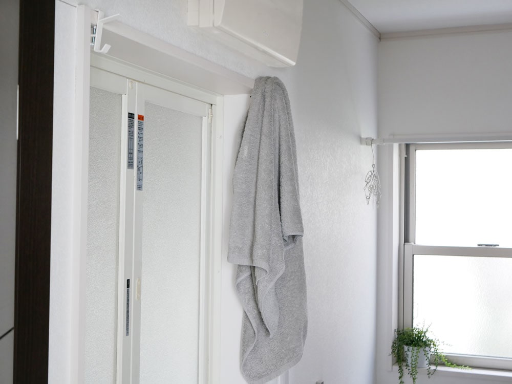 室内窓枠に取り付けられた灰色のタワー物干しフック