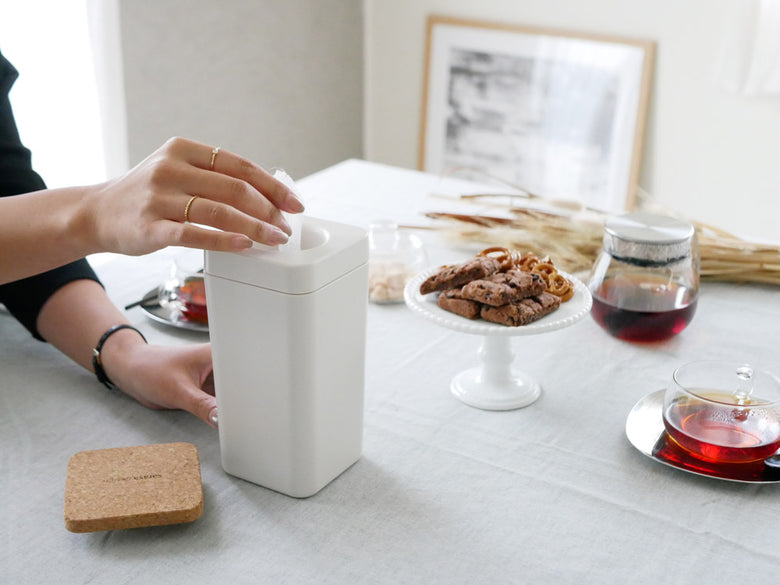 サラサデザインのウエットティッシュスタンド。ABS製の円筒形本体にシリコン蓋が付いた白色のテーブル用スタンドで、高さ約19cm。