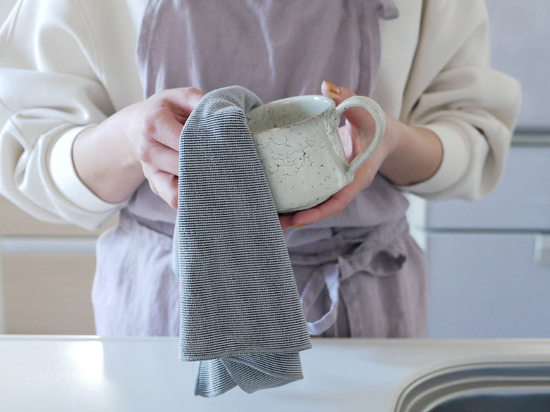 【BIRDY. Supply】ポリエステル70％とナイロン30％で作られたキッチンタオル、サイズは約40cm×70cm、白色で折りたたまれてキッチンのテーブル上に配置されています