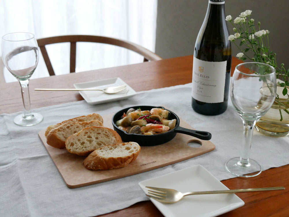 epicurean（エピキュリアン）のセルロース繊維製カッティングボードに食材や食器が配置されたテーブルの風景