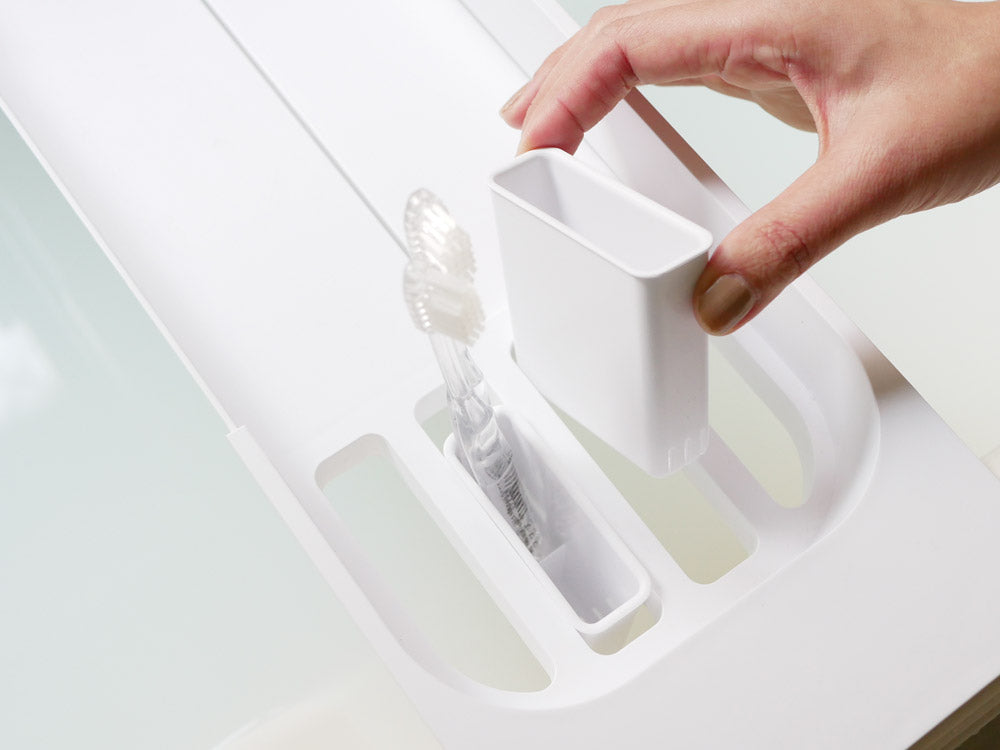 浴槽に設置された山崎のタワー伸縮バスタブトレー。飲み物や入浴用品を置けるABS樹脂製で、幅調整可能な実用的なデザイン