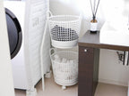 洗濯室に置かれた2段ランドリーバスケットと洗濯機