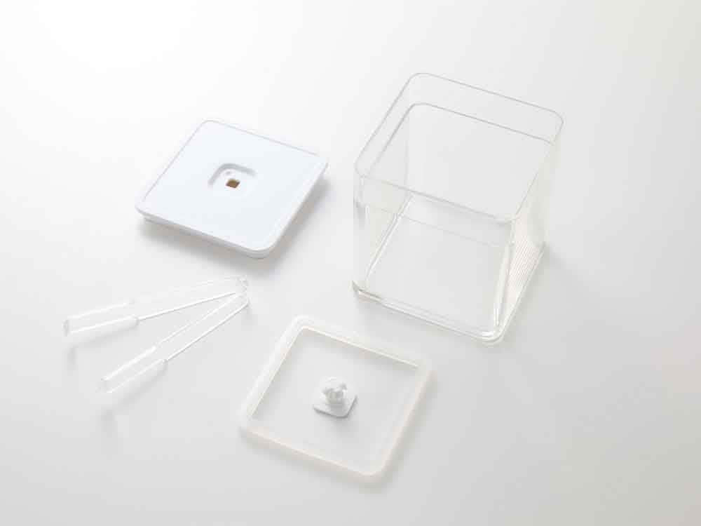透明なプラスチック製密閉保存容器と蓋がトレイに置かれている