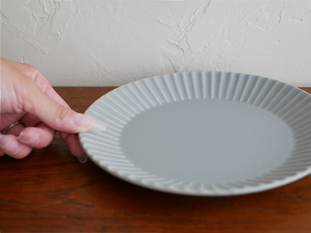 白とグレーの磁器製「Stripe」シリーズの丸皿がテーブルに美しく並べられた写真
