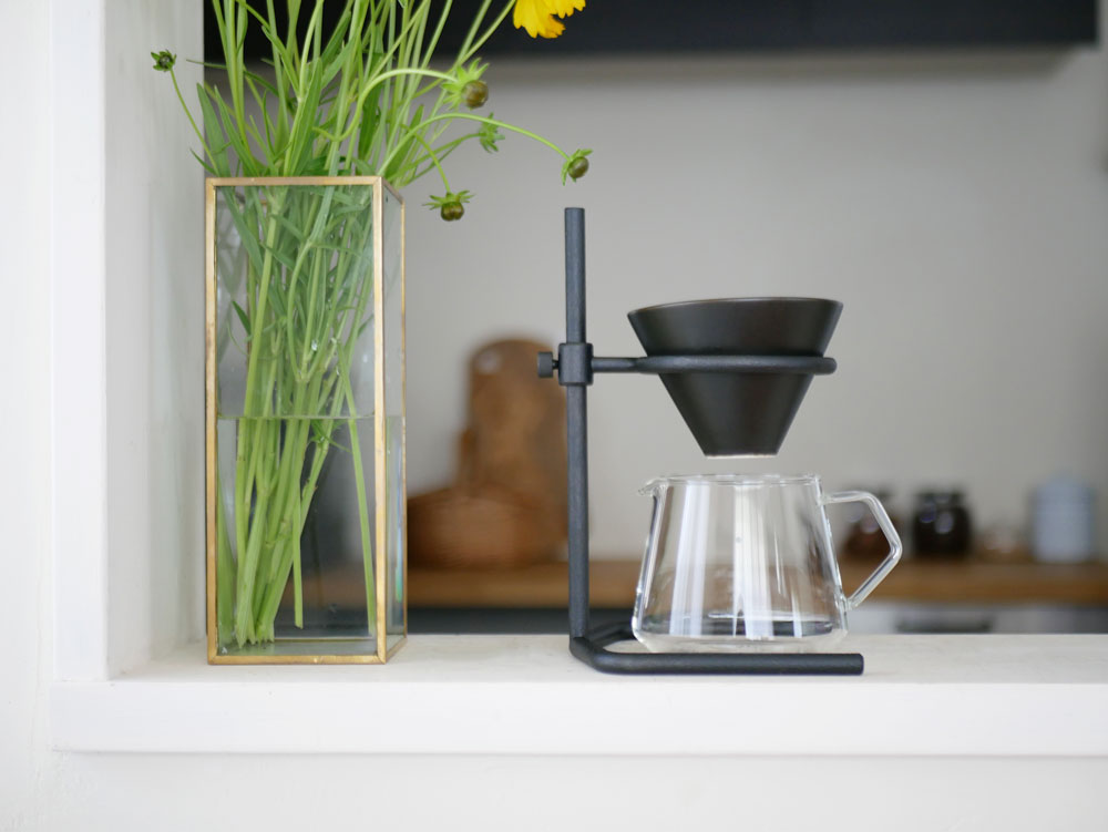 キントーの黒色ブリュワースタンドセットとカップ、ティーポットが棚に並んだスタイリッシュな静物写真