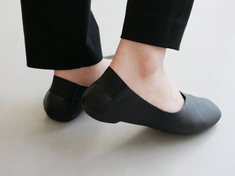 レ プリエ ノイエのレザー携帯スリッポンと白いソックス、タイトなタイツを履いた足元の画像