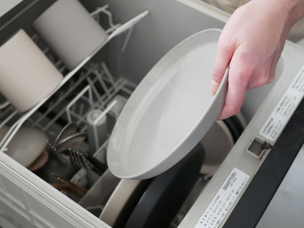 手作りのベトナム製せっ器プレートセット（Φ260×H18mm、Φ210×H18mm、Φ150×H16mm）がキッチンの食洗機付きラックに整然と並べられた様子。