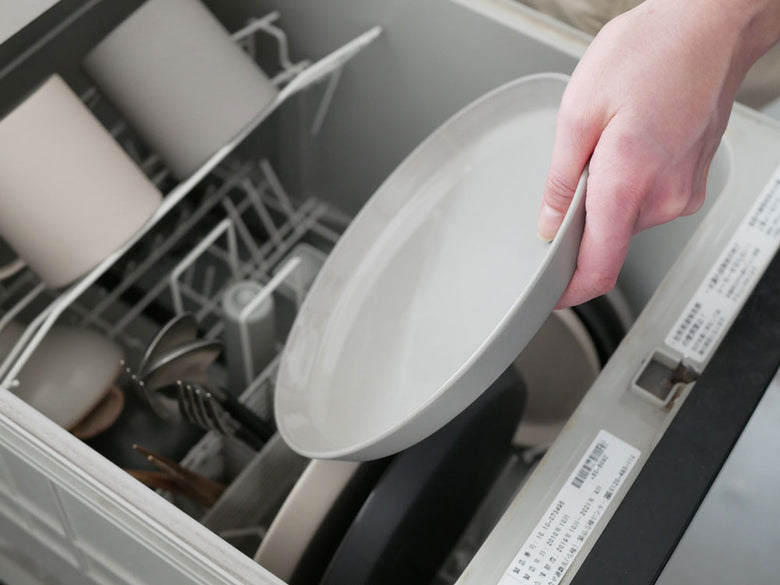 手作りのベトナム製せっ器プレートセット（Φ260×H18mm、Φ210×H18mm、Φ150×H16mm）がキッチンの食洗機付きラックに整然と並べられた様子。