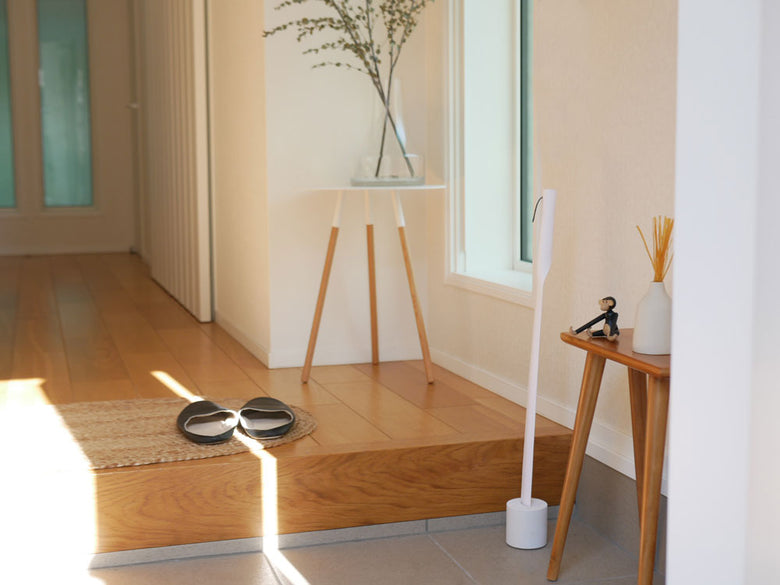 木製のフローリング上にMOHEIM（モヘイム）のシューホーンが置かれ、周囲に家具や観葉植物が配置されている様子