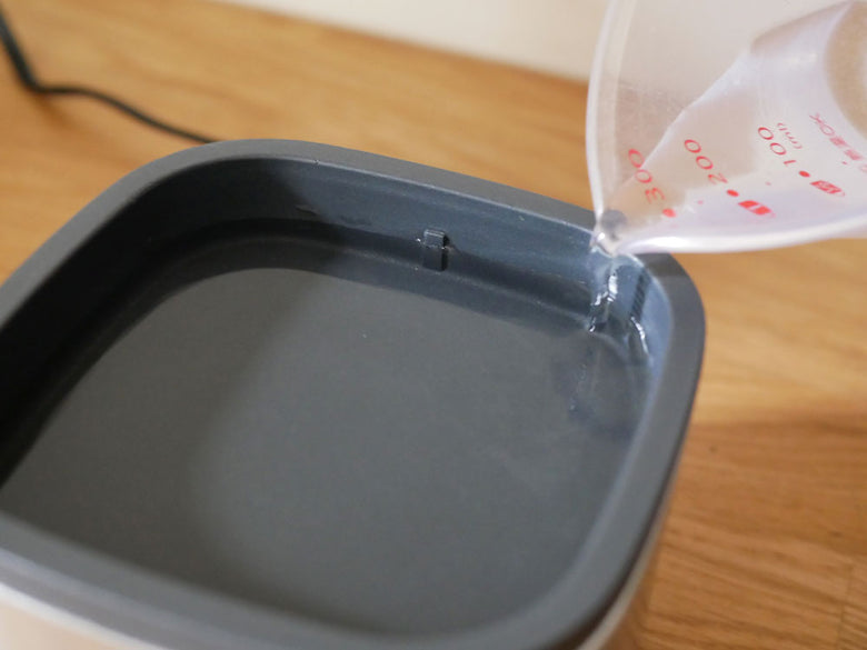 Russell Hobbsクイックミニスチーマー本体と付属のエッグトレイ2枚、スチーム皿2枚を並べたキッチン用品の画像