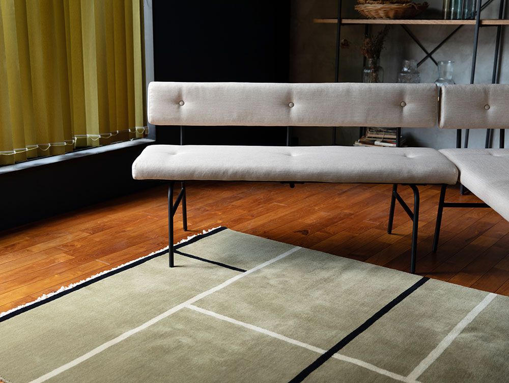 グレーのアデペシュ・サムノルドベンチソファが木製フローリングの上に配置されている様子