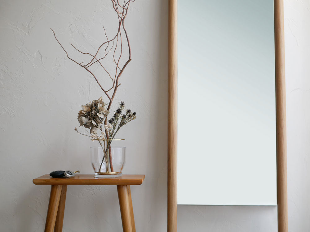 フリッツ・ハンセンのIKEBANA、木製の花瓶に生けられた観葉植物と木材の背景が特徴のアレンジメント