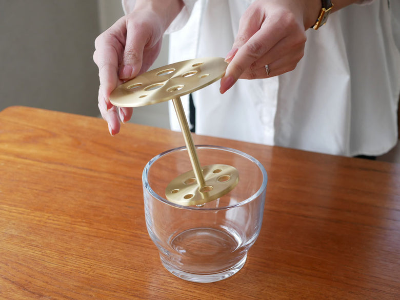 フリッツ・ハンセンのIKEBANAテーブルウェアセット。真鍮製のスプーンやストローがガラスの器と共に並んでいる