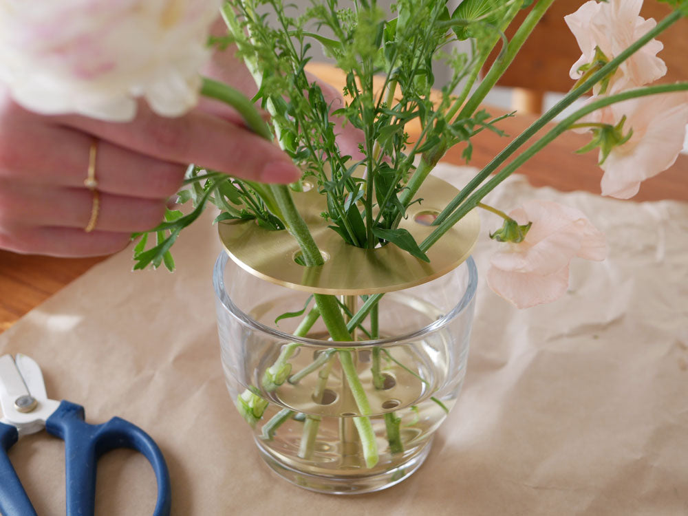 フリッツ・ハンセンのIKEBANAアレンジメントが花瓶に美しく生けられた様子。切り花と人工花が調和した中心装飾です。