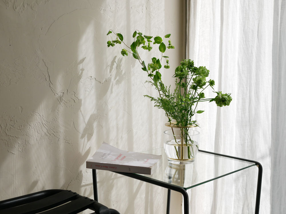 フリッツ・ハンセン「IKEBANA」シリーズの真鍮とガラス製器に生けられたハウスプラントと傘形科植物の美しい生花アレンジメント