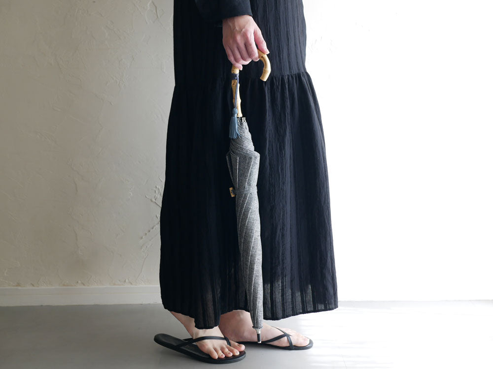 becauseのプレーンカラー長傘のストラップ部分とリネン風テクスチャーを示す画像