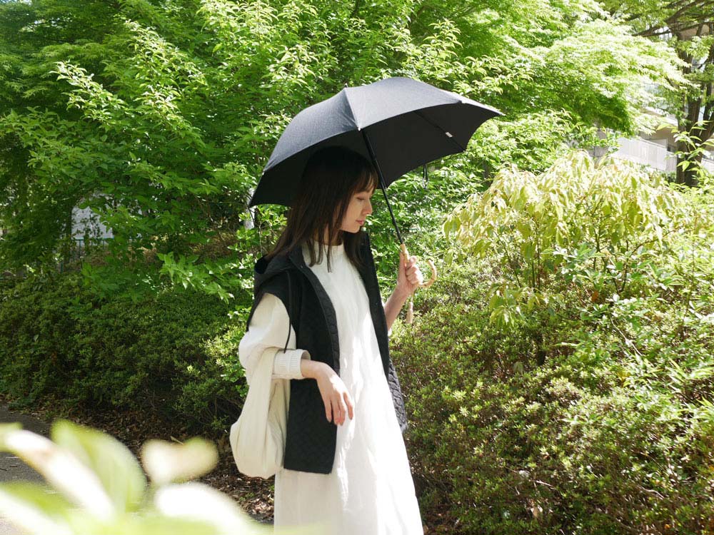 ビコーズのプレーンカラー長傘とスタイリッシュなハンドバッグが一緒に写っている画像