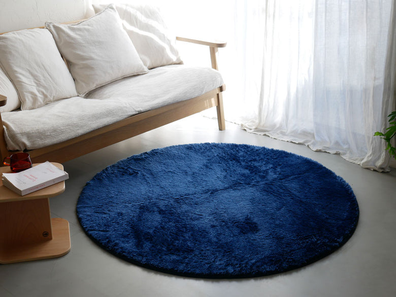 【HOPPL/ホップル】直径130cmのポリエステル製円形ラグがリビングルームの木製フローリングに敷かれている様子