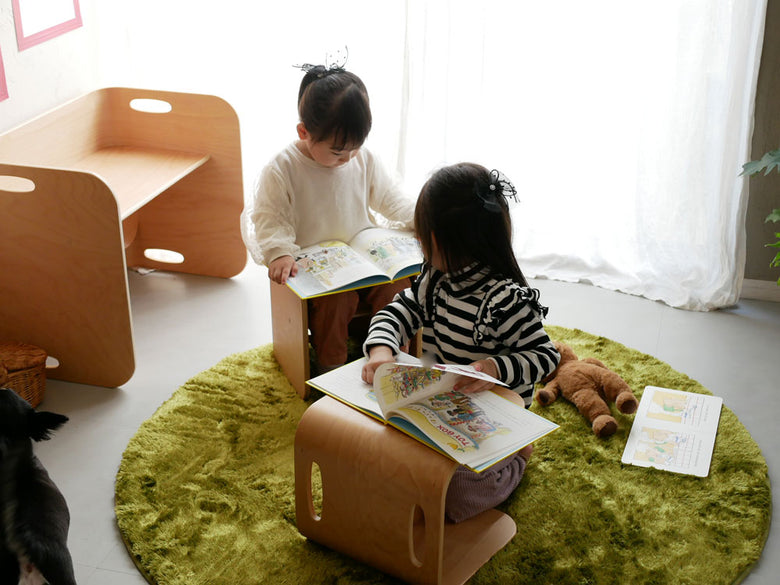 リビングルームに配置されたホップルの直径130cm円形ラグの上で幼児が遊んでいる様子