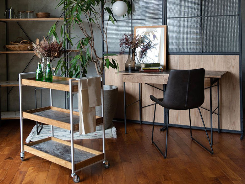 アデペシュのPOLデスクがオーク無垢材の床とモダンなインテリアに配置された室内の写真。