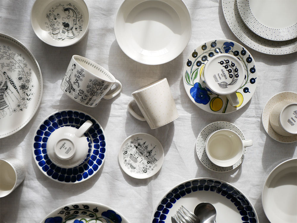 アラビア24hトゥオキオシリーズの青白い磁器製プレートとディーププレートが並べられたダイニングウェアセット