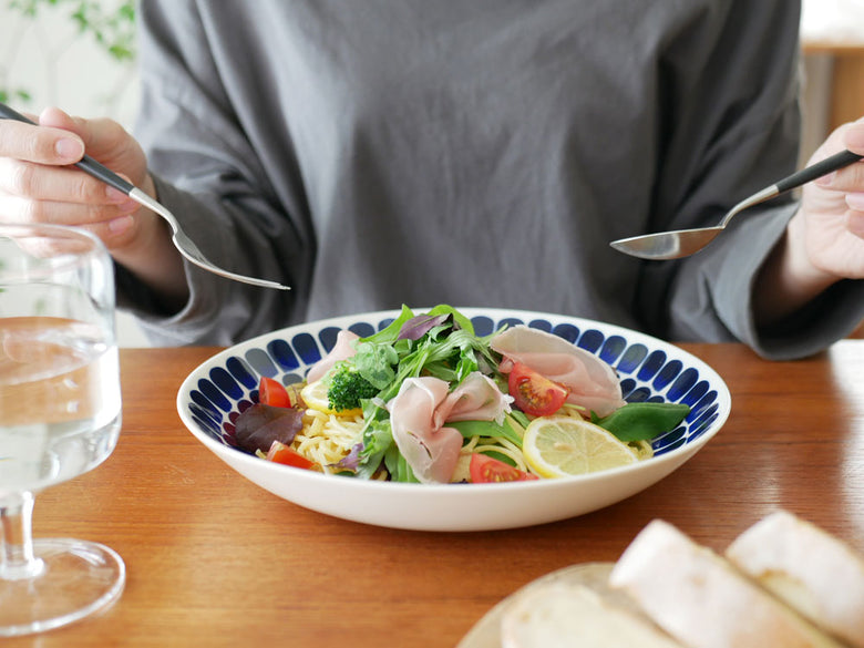 アラビア製磁器の24hトゥオキオプレートとディーププレートに盛り付けられたカラフルなサラダと果物の食卓シーン