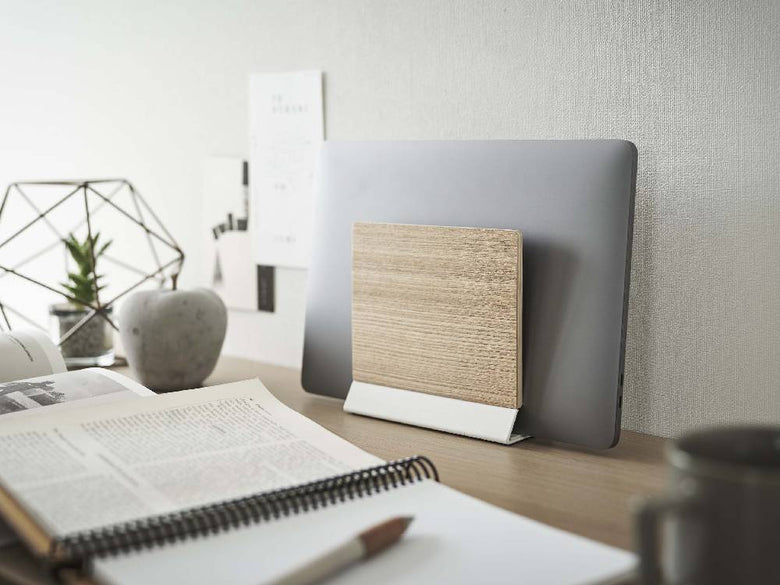 天然木とスチール製のスリムなノートパソコンスタンドがオフィスのデスク上に置かれている様子