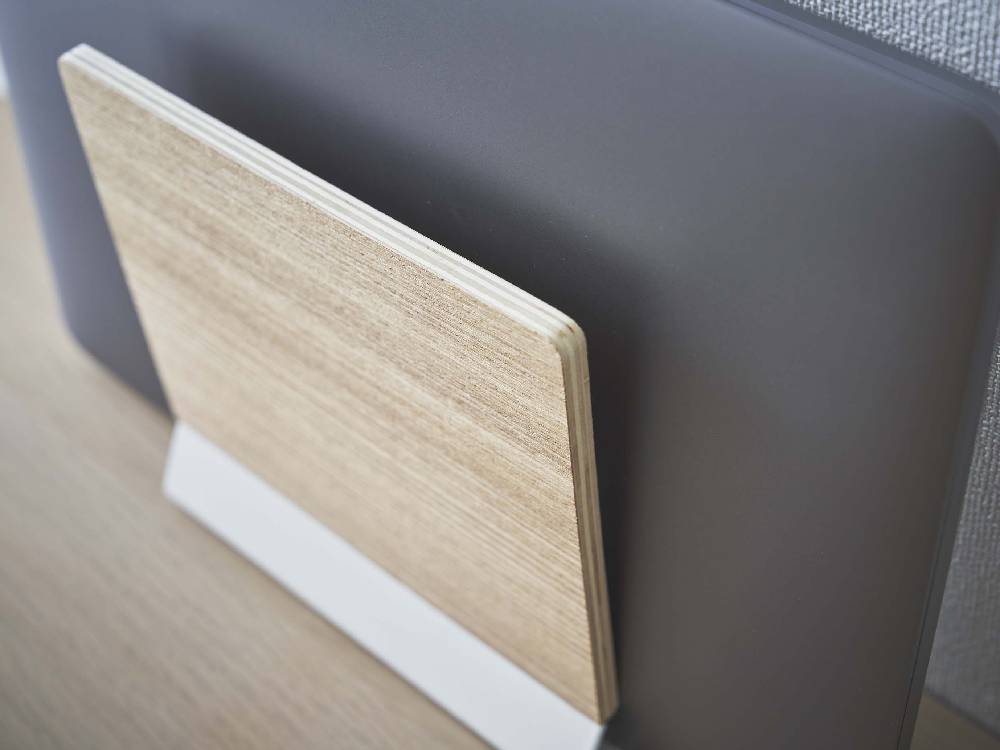 天然木とスチールで作られたスリムなノートパソコンスタンドにノートパソコンが置かれている様子