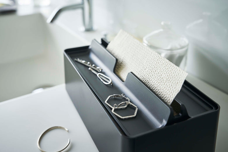 シルバー色のトレー蓋付きペーパータオルケースがテーブル上に配置された静物写真