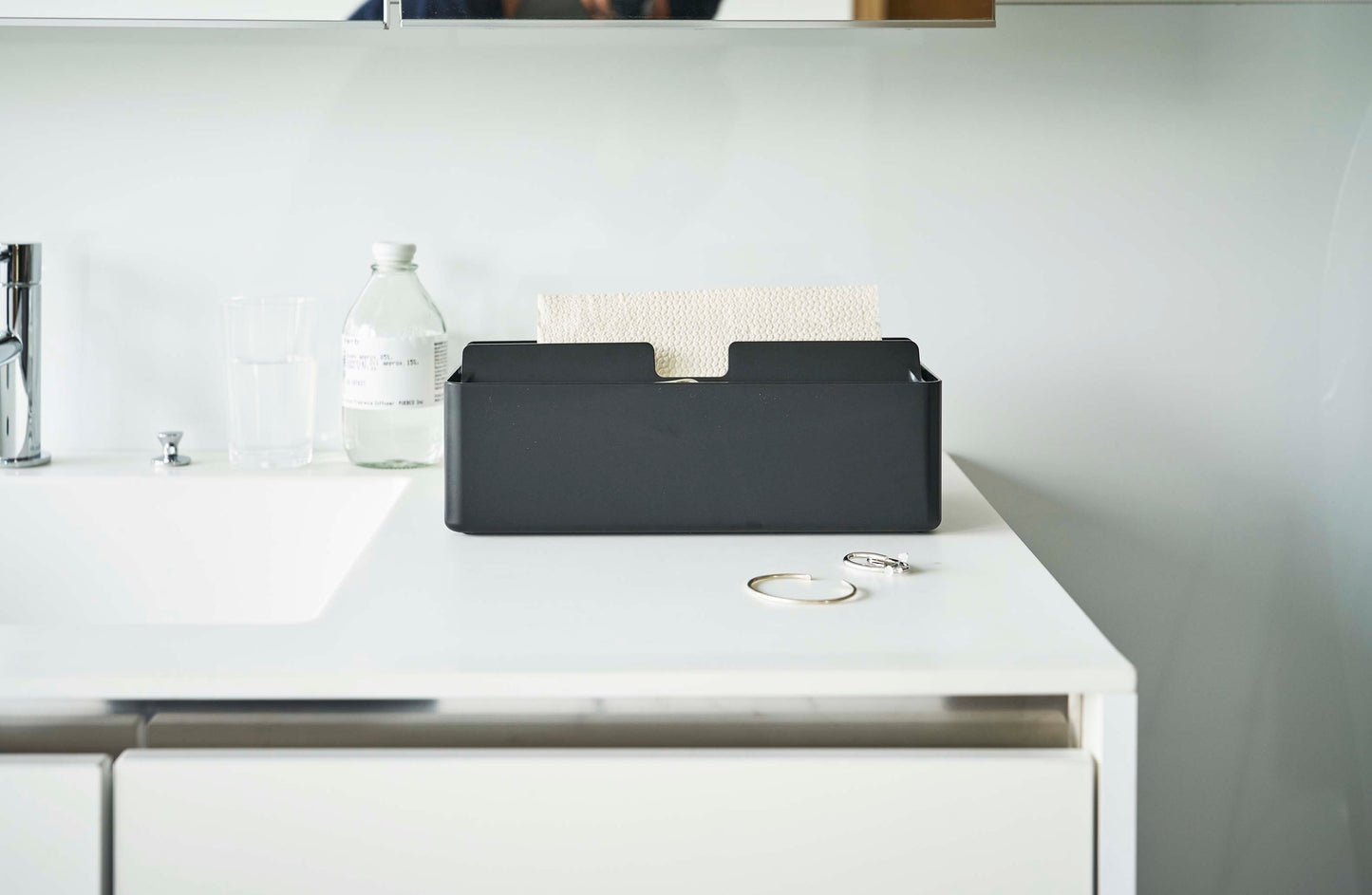 銀色のトレー蓋付きペーパータオルケースがシンク周りの家庭用品とともにキッチンに設置されている