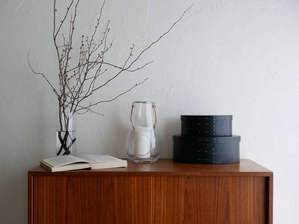 ホルムガード DESIGN WITH LIGHT ランタンが木製のサイドボードとキャビネットの上に置かれたインテリア写真