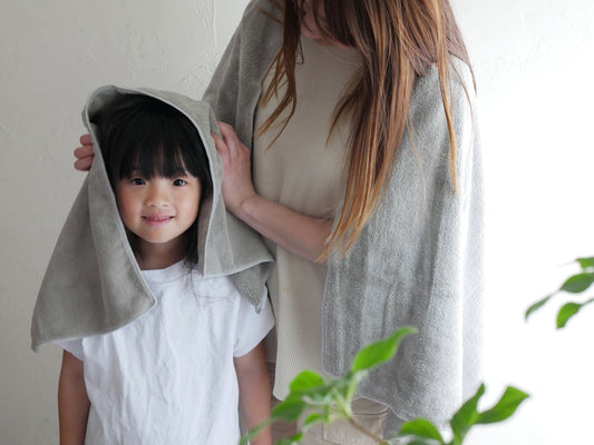 シービージャパンのカラリデイバスタオルとフェイスタオルを持つ笑顔の幼児モデルのポートレート写真