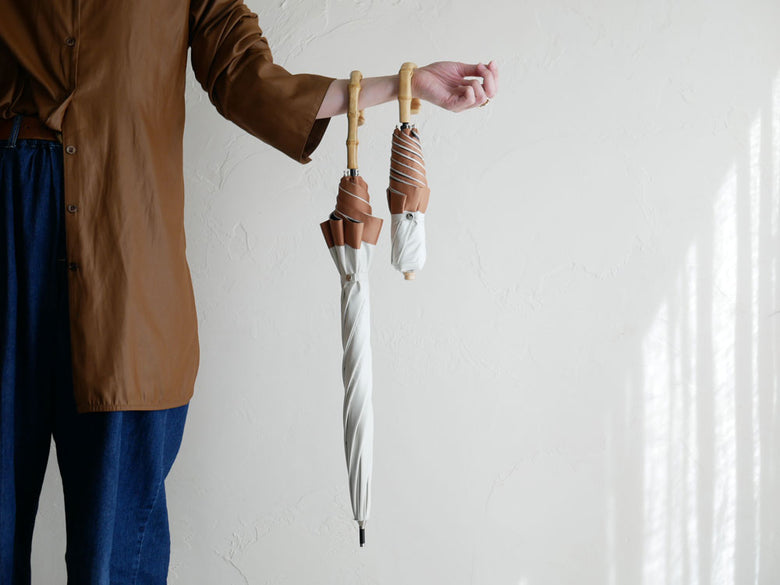 清潔感のあるビコーズ PUグログラン長傘、バンブーハンドルにロープと結び目が特徴